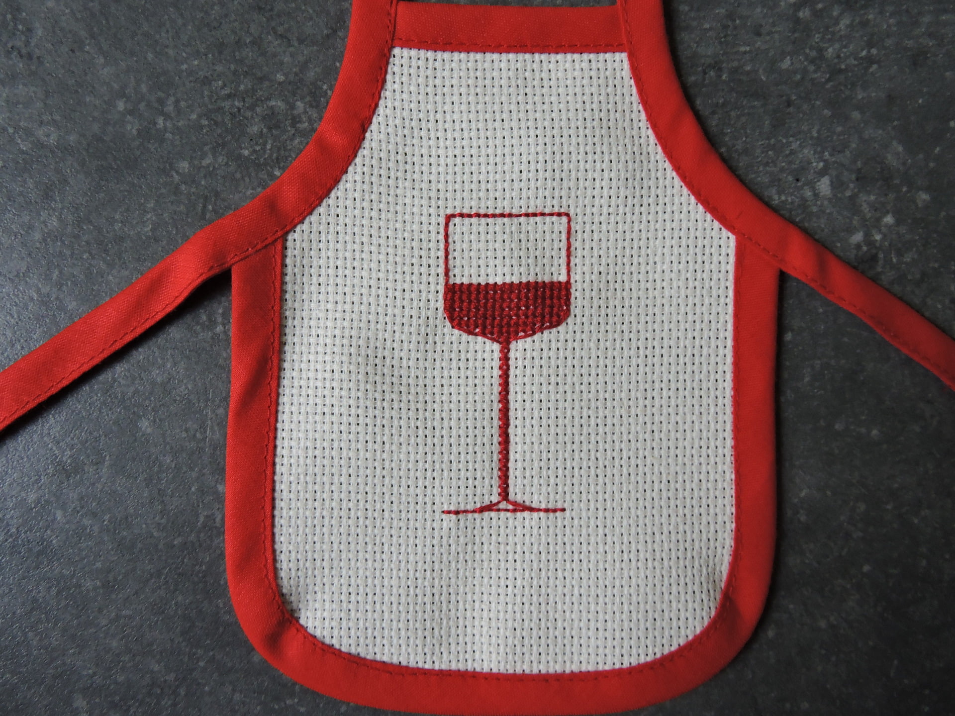 A pretty wine bottle apron with a deep red wine glass pattern The